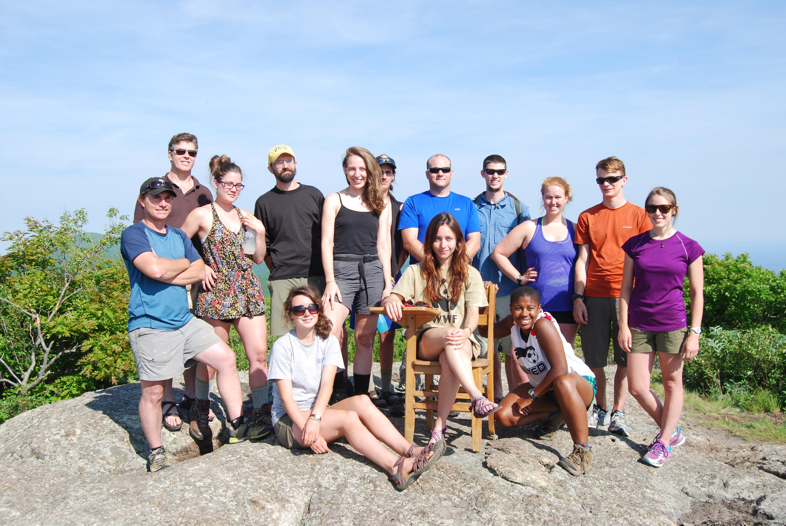A group of men and women pose outside.