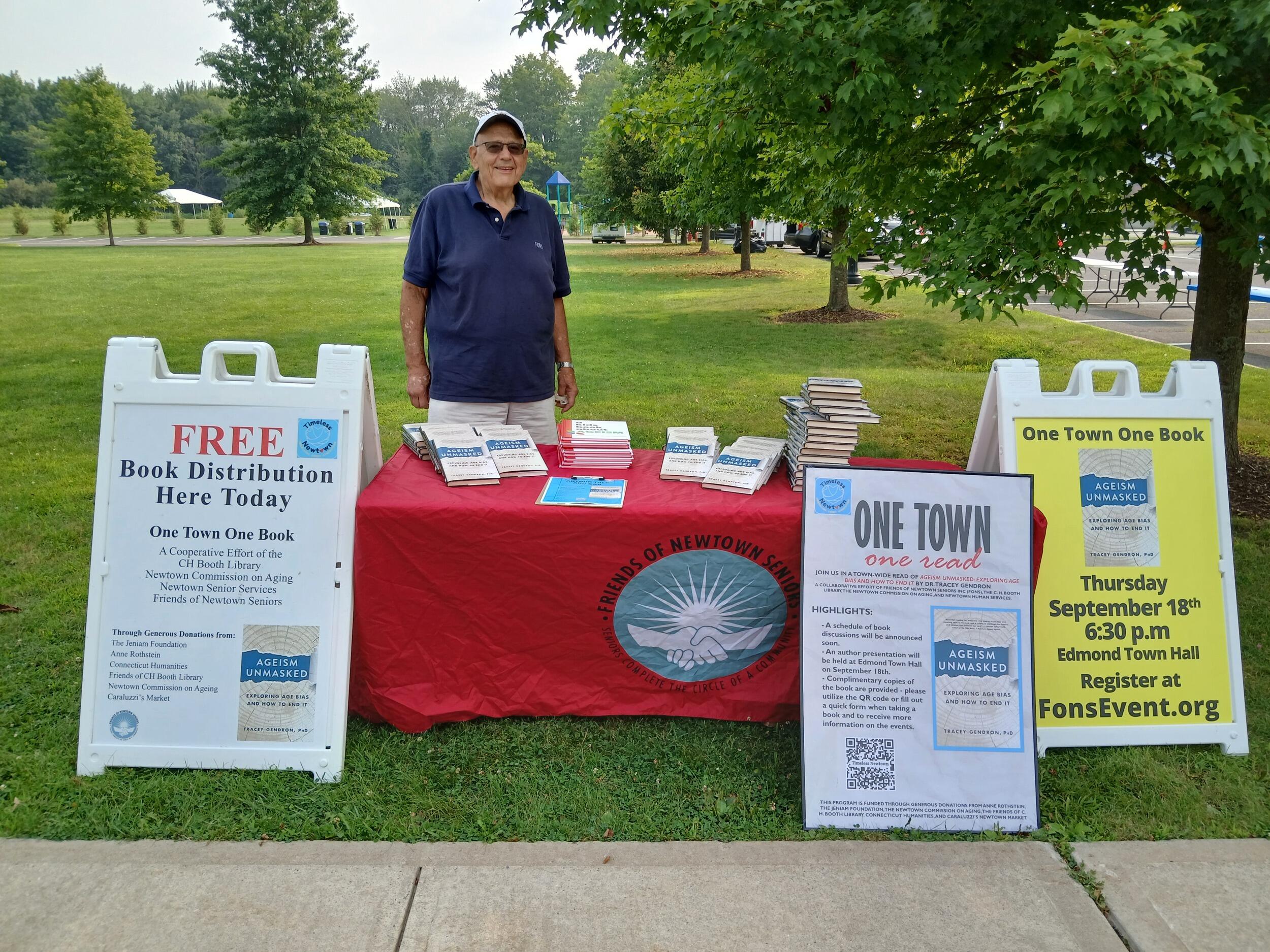 A photo of a man standing behind a booth. 