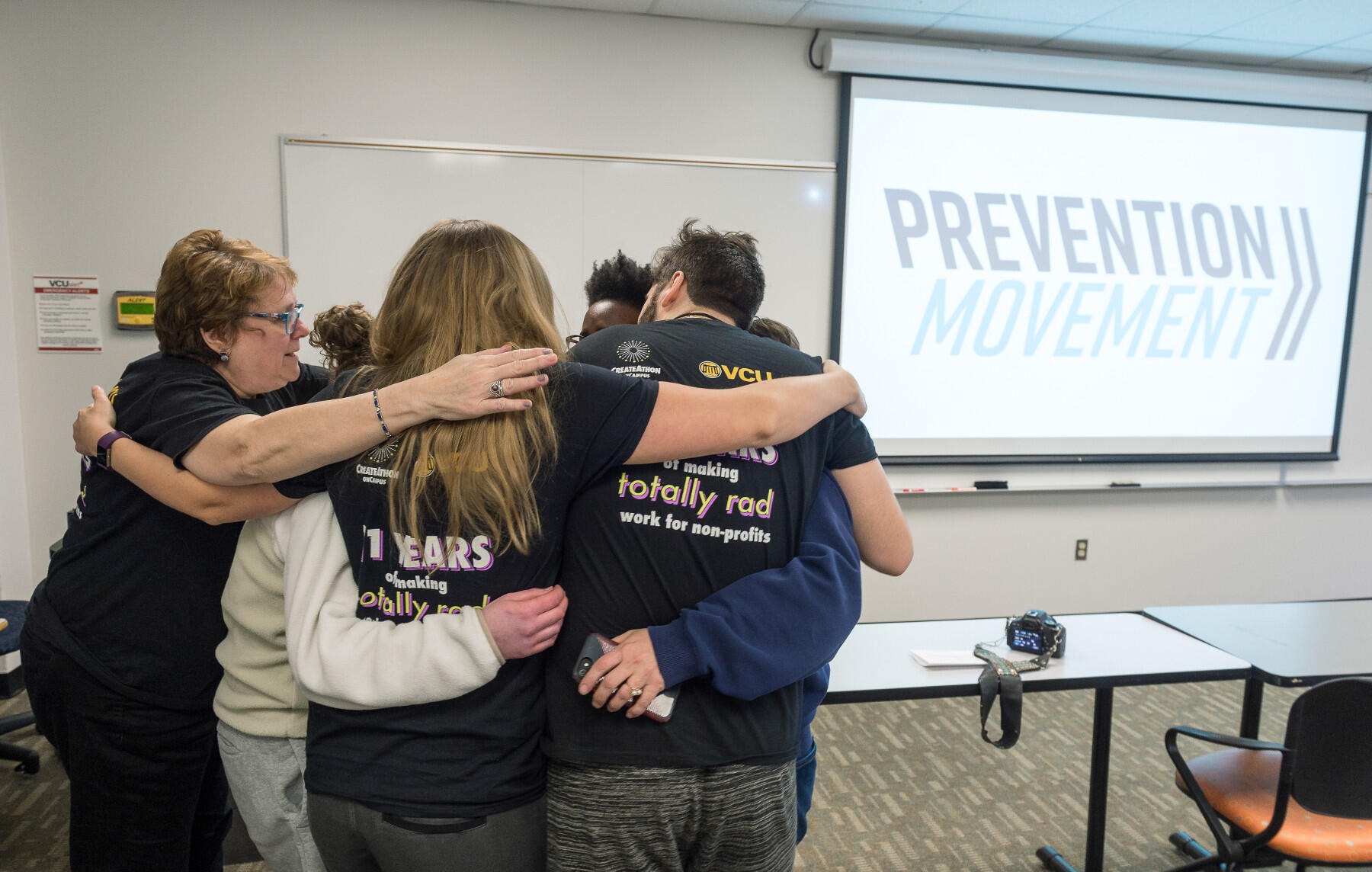 Heather Caleb, operations and engagement manager for the Richmond Justice Initiative, shares a hug with the team of VCU students who produced pro bono marketing services for the nonprofit anti-human trafficking organization.