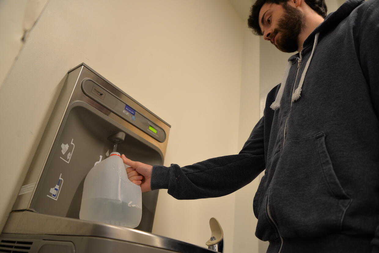 VCU student Raphael Debraine fills a water jug in James Branch Cabell Library