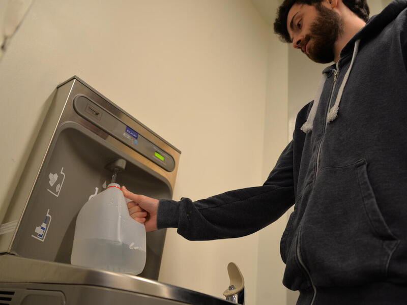 VCU student Raphael Debraine fills a water jug in James Branch Cabell Library