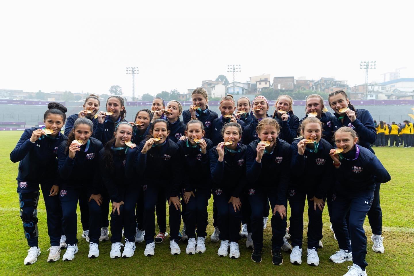 A group of women biting gold medals 