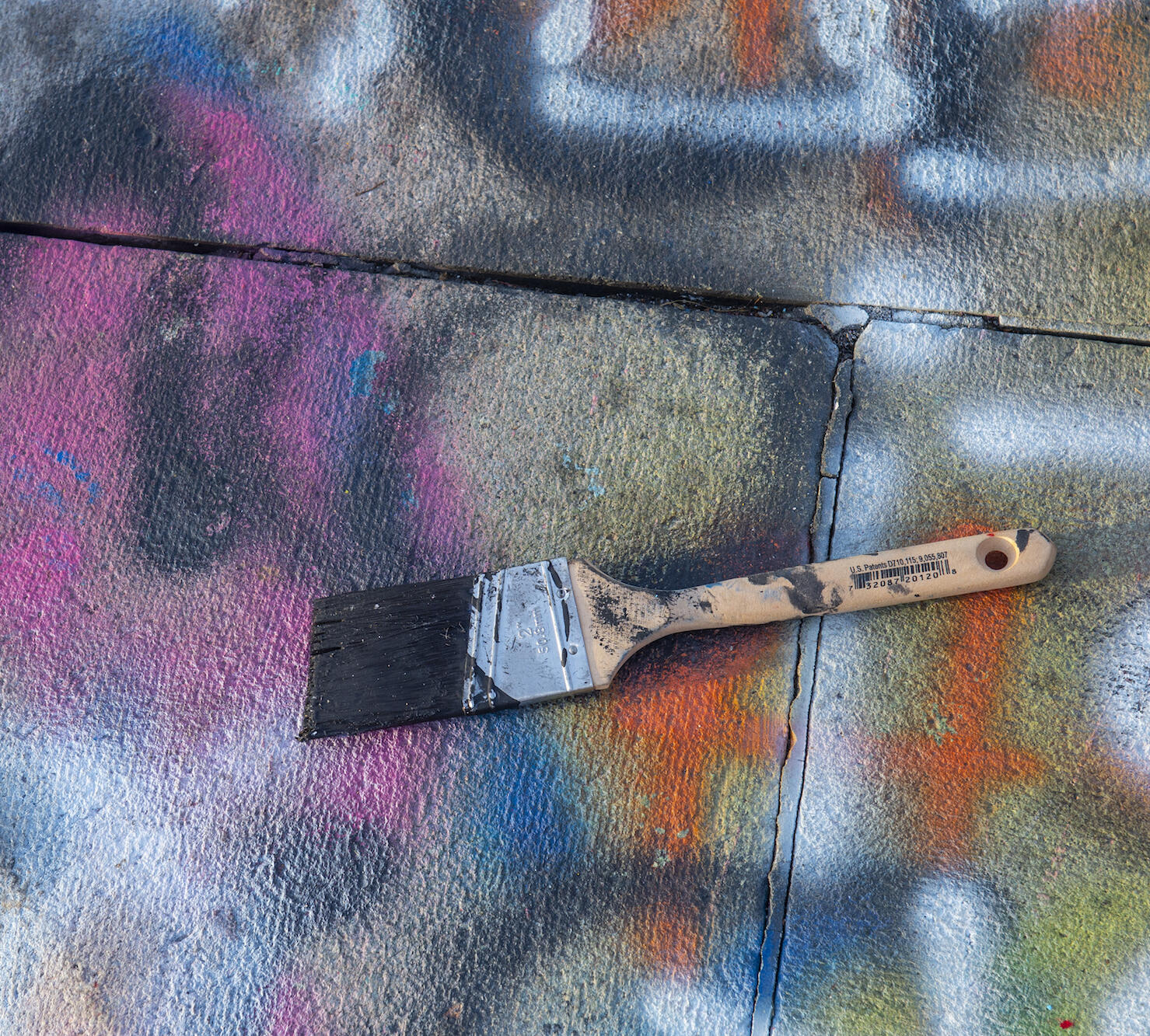 paint brush on a paint-colored sidewalk
