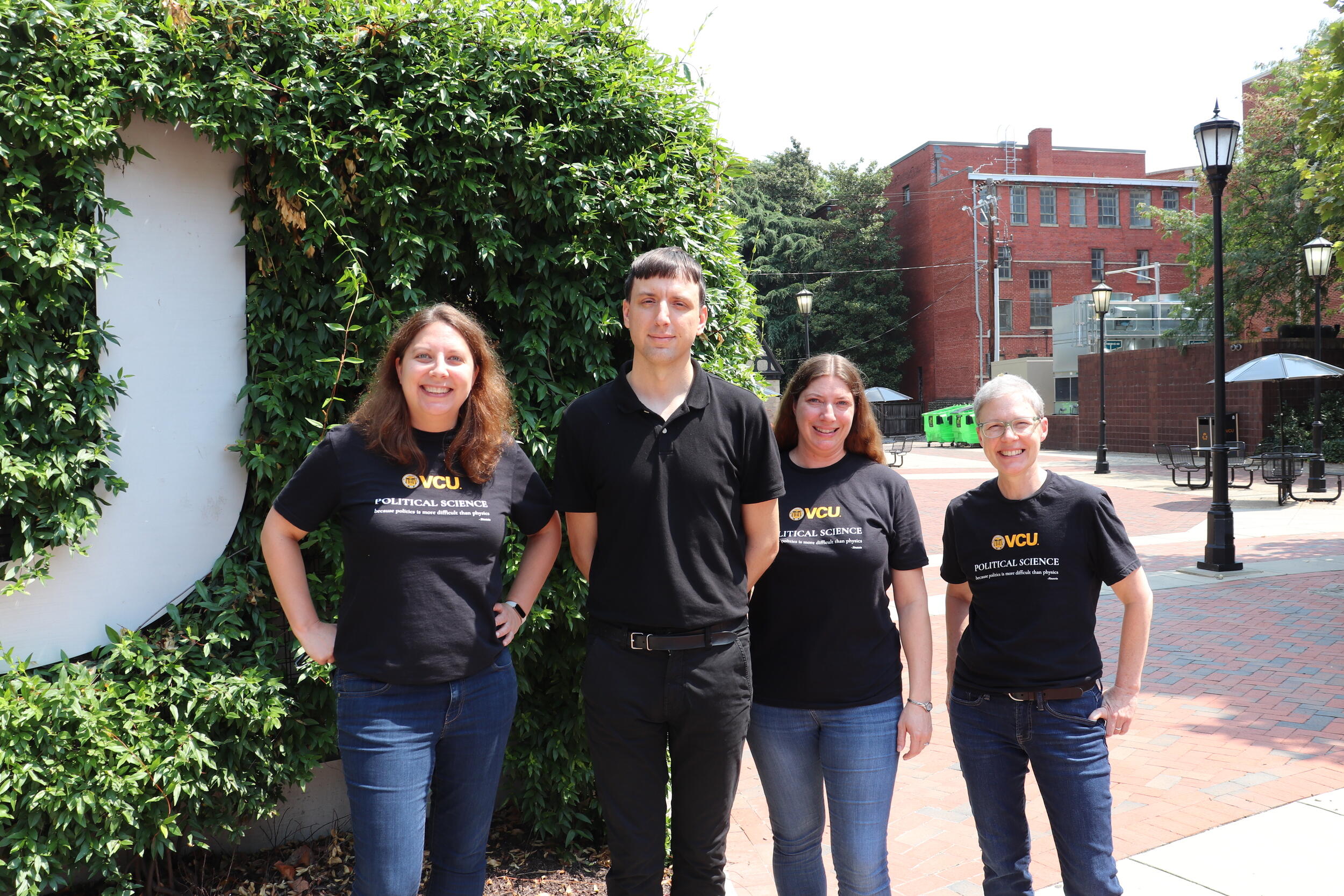 A photo of four people standing outside. 