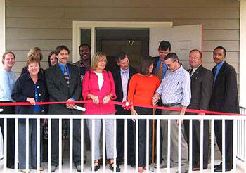 R. Macon Sizemore (center), president of Independence House, leads 12 other volunteers and supporters at the ribbon cutting for the community-based group home.

Photo courtesy of Virginia Supportive Housing