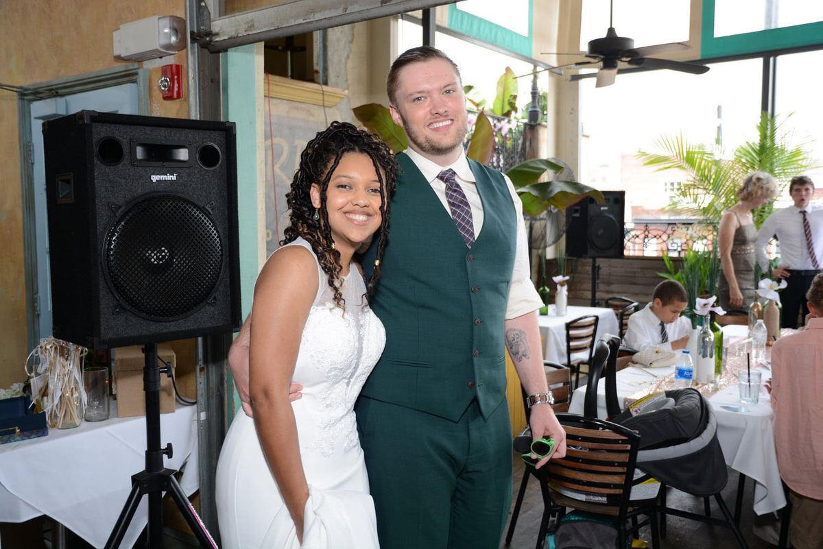 A photo of a man in a suit and a woman in a wedding dress standing.