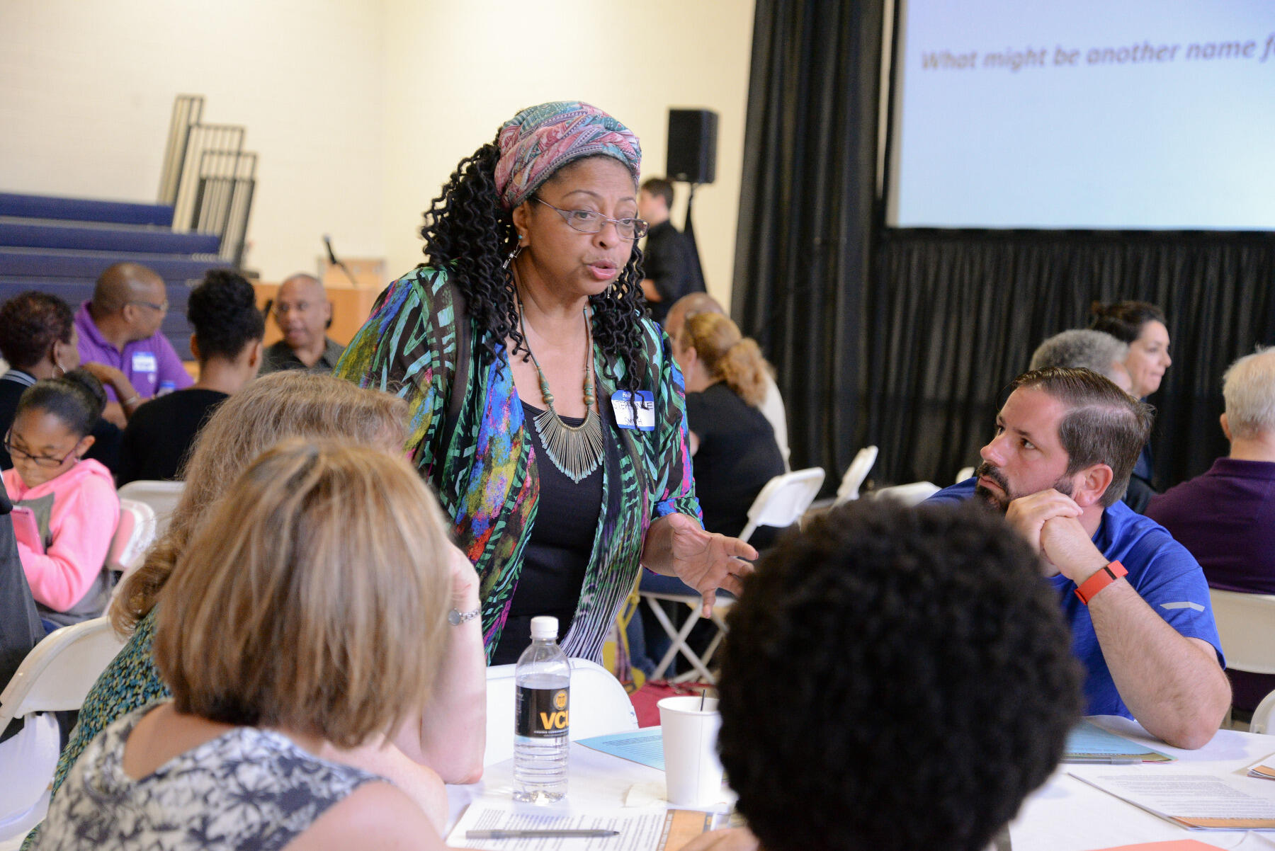 Stephanie Smith, a member of the East Marshall Street Well Project's Family Representative Council, talks with others during a community meeting held at Martin Luther King Jr. Middle School in Richmond.