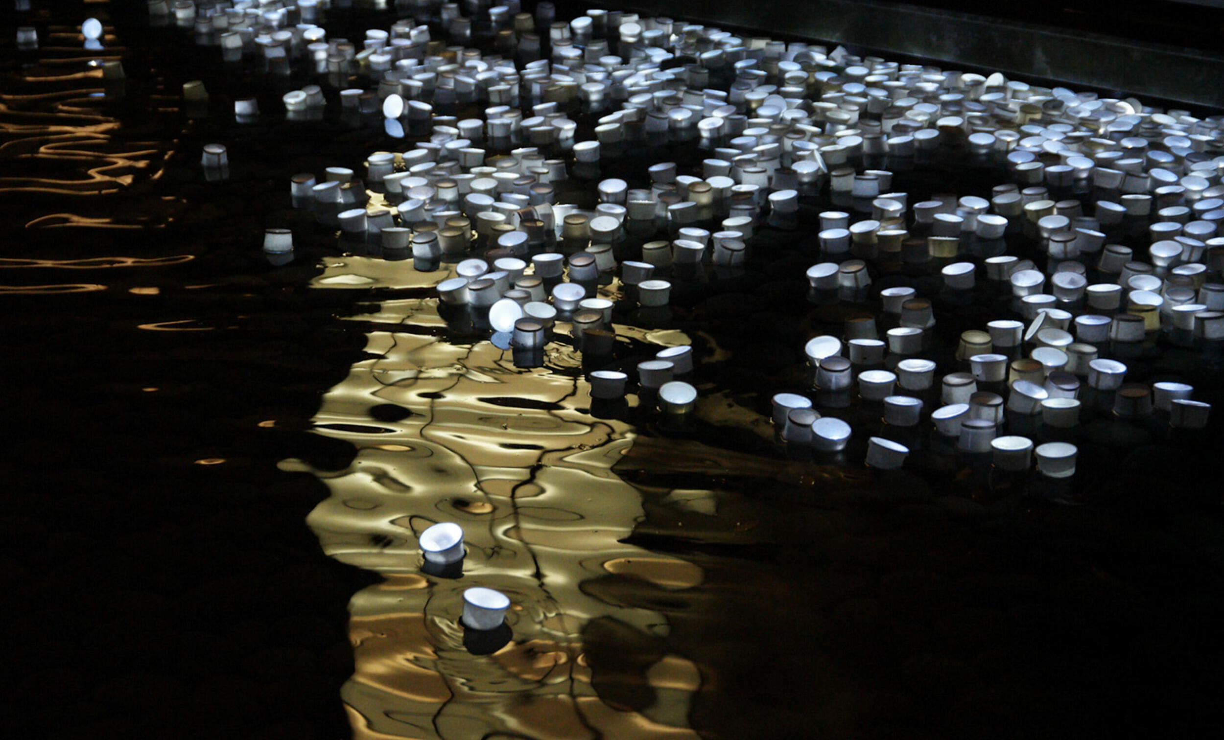 A photo of water with lights floating on it. 