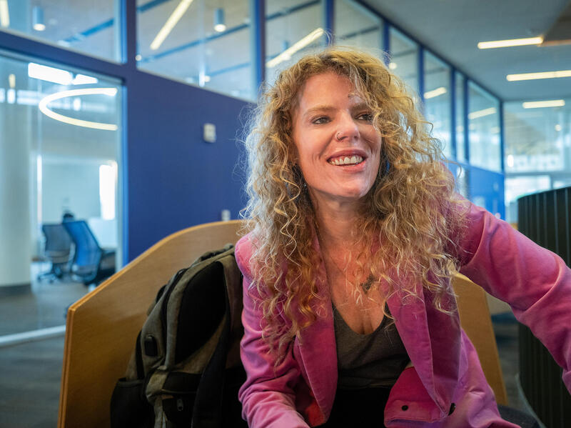 A photo of a woman lookng to the right while sitting down. 