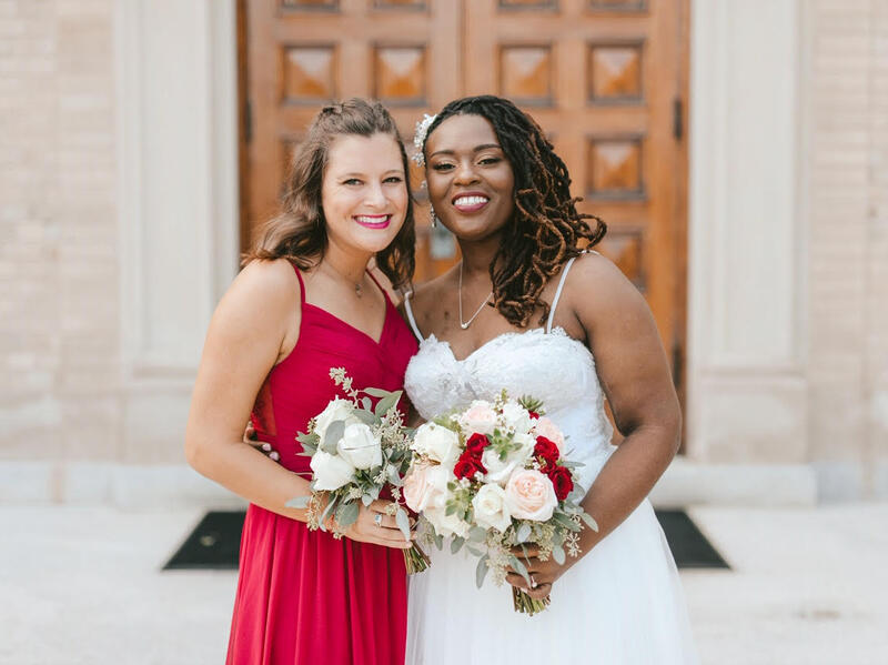 A bride and a bridesmaid standing in front of a church.