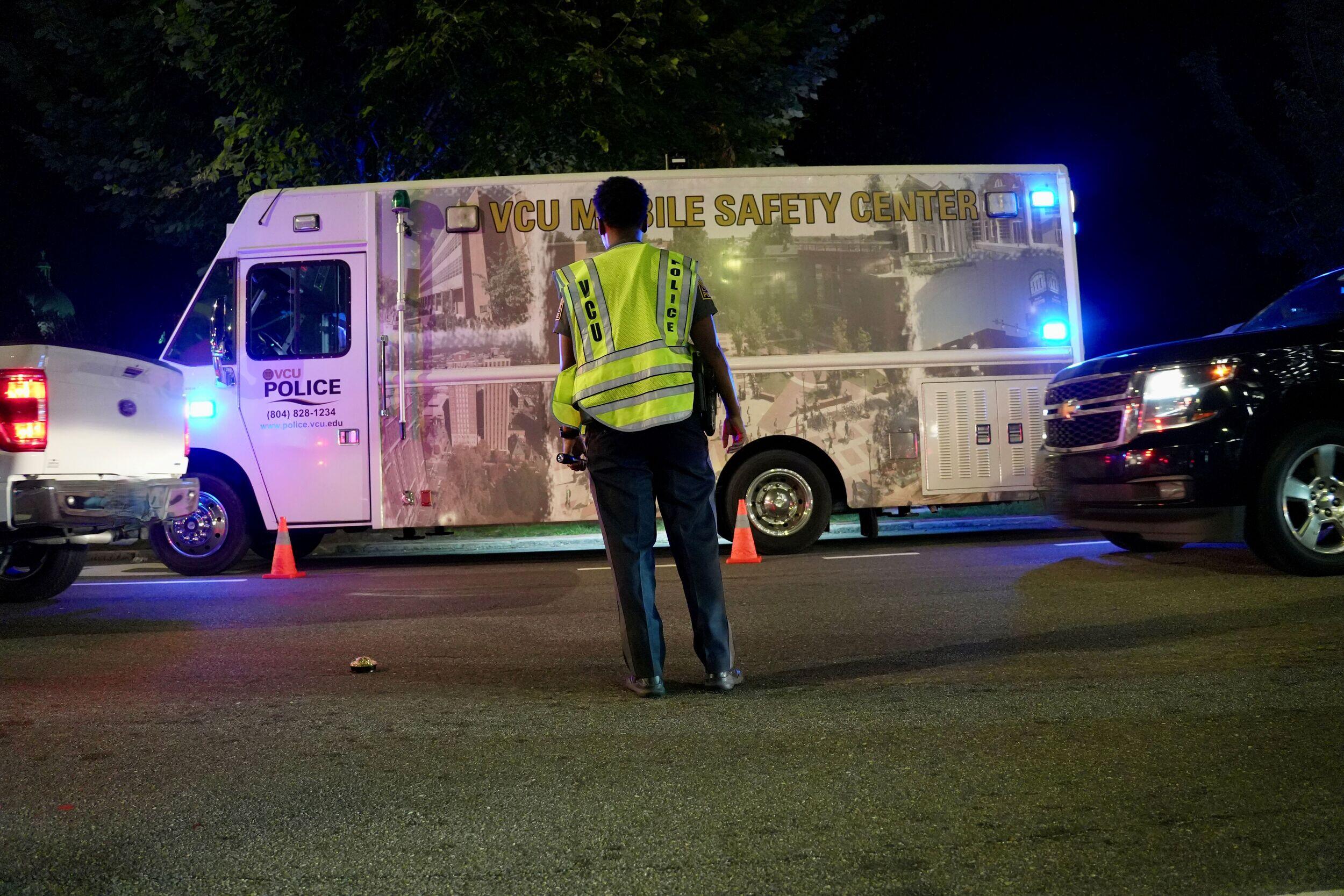 A police officer stands in front of a police van.