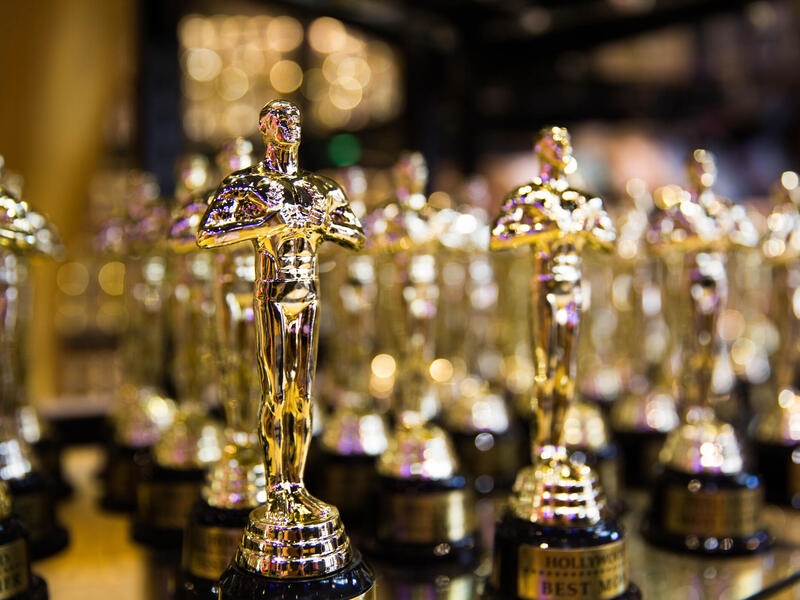 A photo of dozens of Oscar awards. 