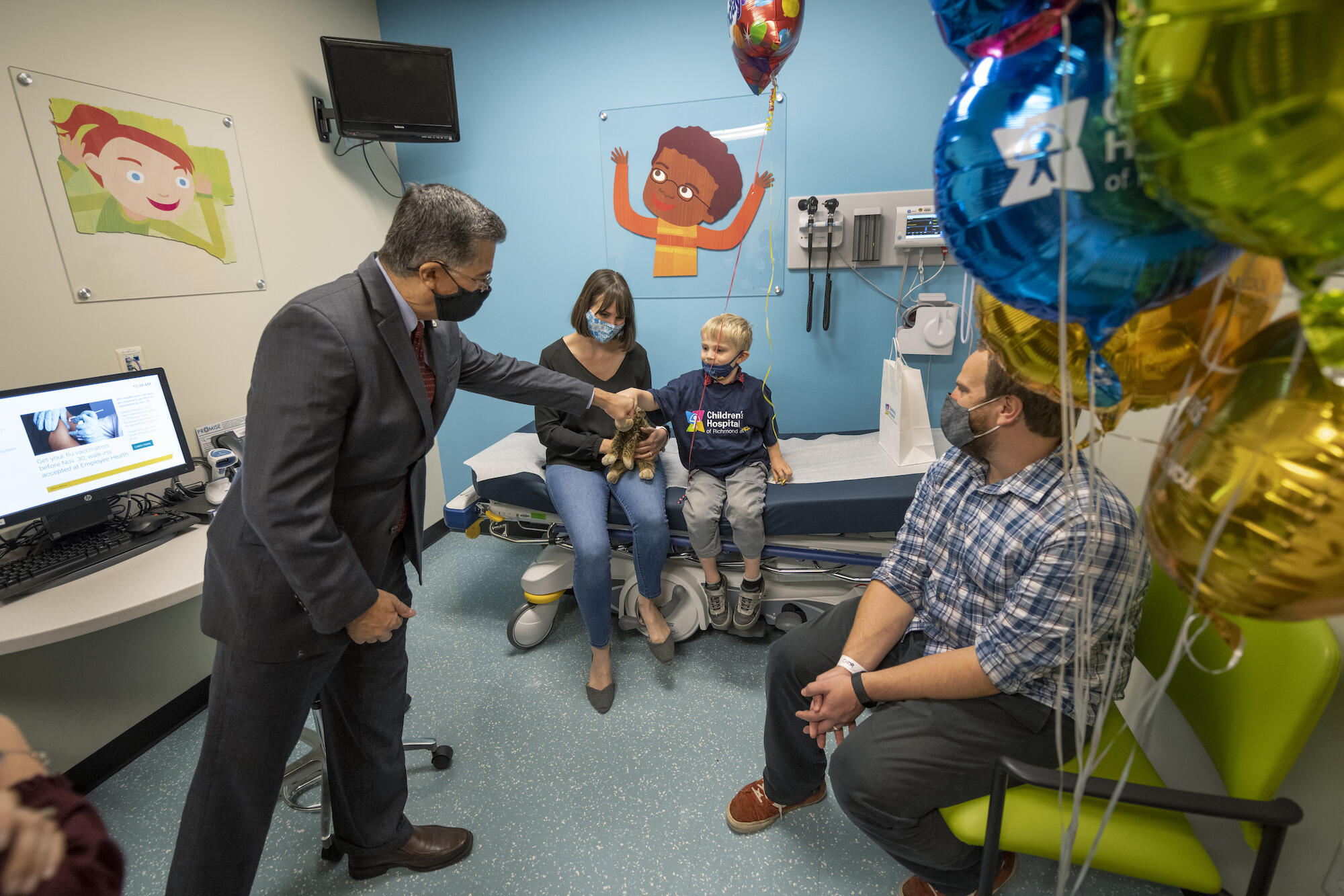 HHS Secretary Xavier Becerra, left, greets Johnny Richter at Children's Hospital of Richmond at VCU