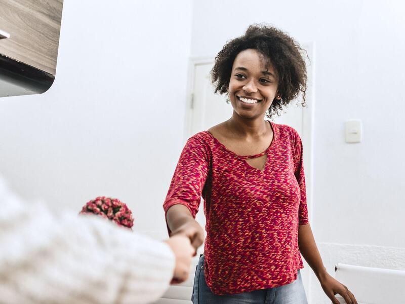 A smiling patient shakes someone's hand.