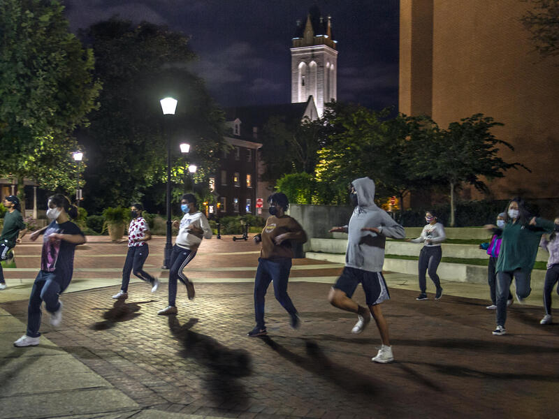students dance outside in the dark