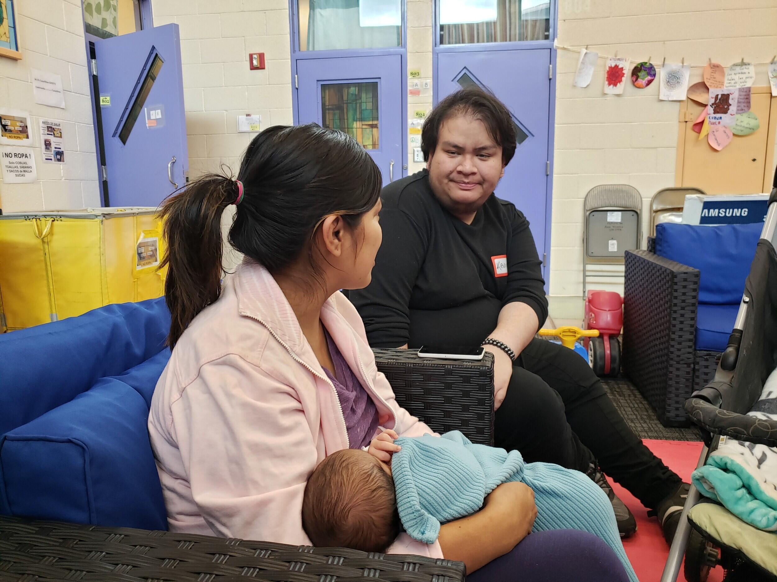 Two people in conversation inside of a classroom.
