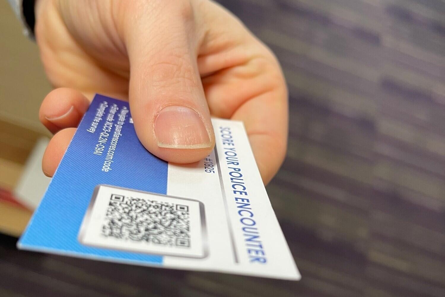 a hand holding a police \"stop\" card