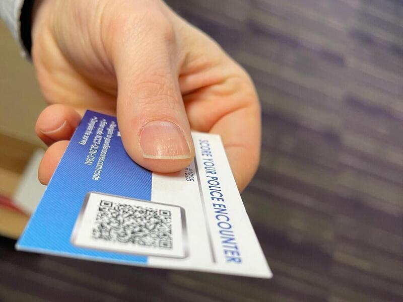 a hand holding a police \"stop\" card