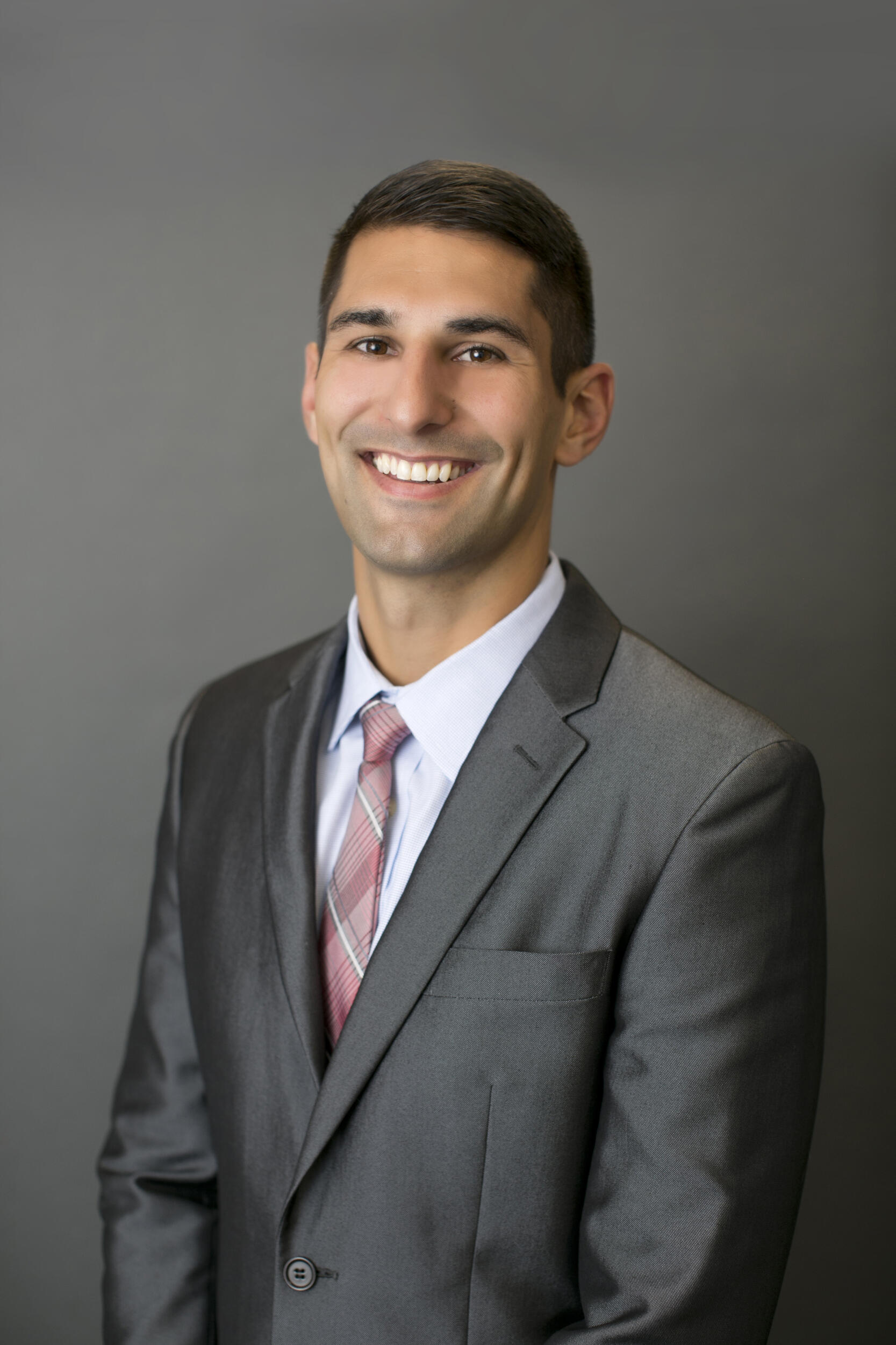 A portrait of a man from the waist up. He is wearing a suit and tie.