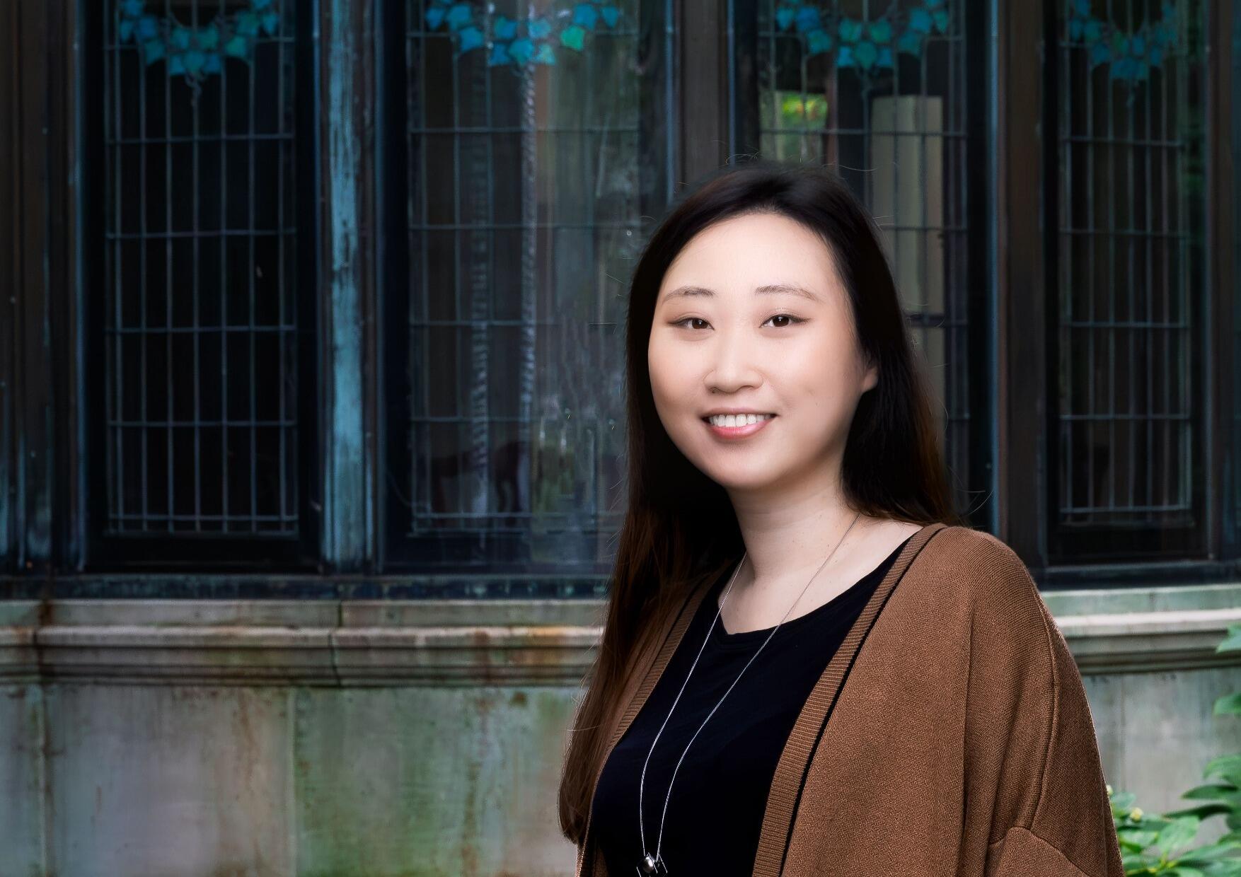 A portrait of a woman standing outside. 