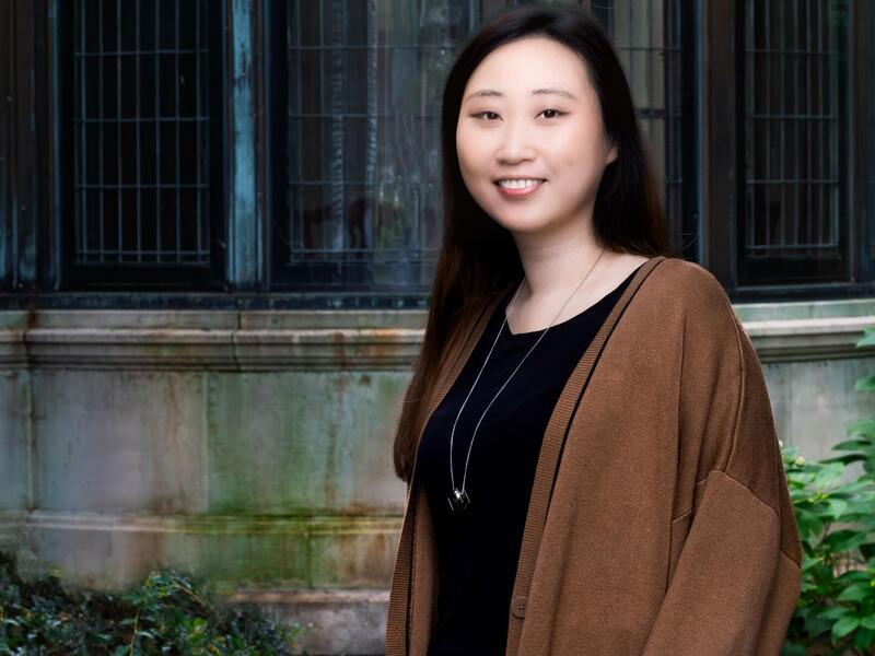 A portrait of a woman standing outside. 