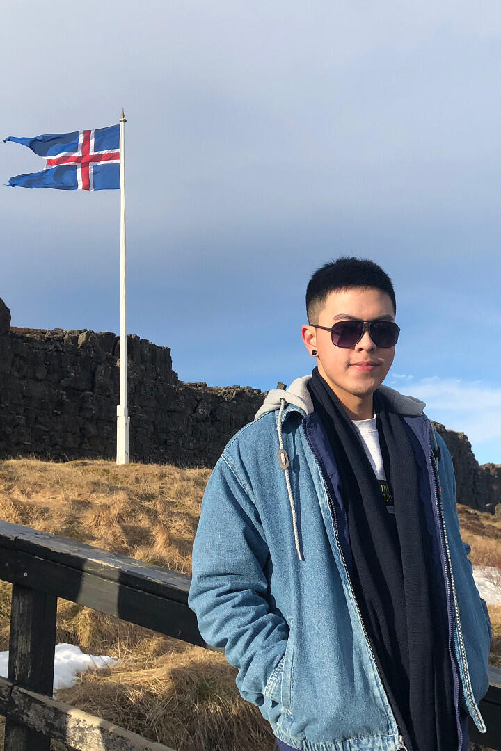 Man standing in front of flag and scenic view.