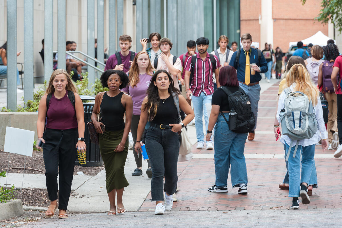 A group of students walking by Cabell Library 