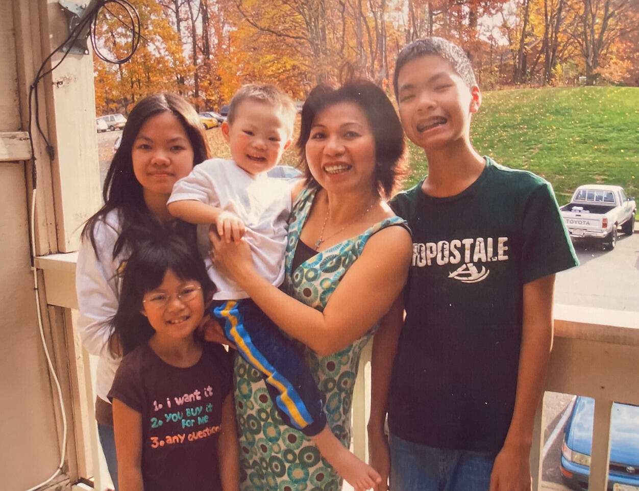 Two girls on the right, a woman holding a little boy in the center, and a boy on the far right. 