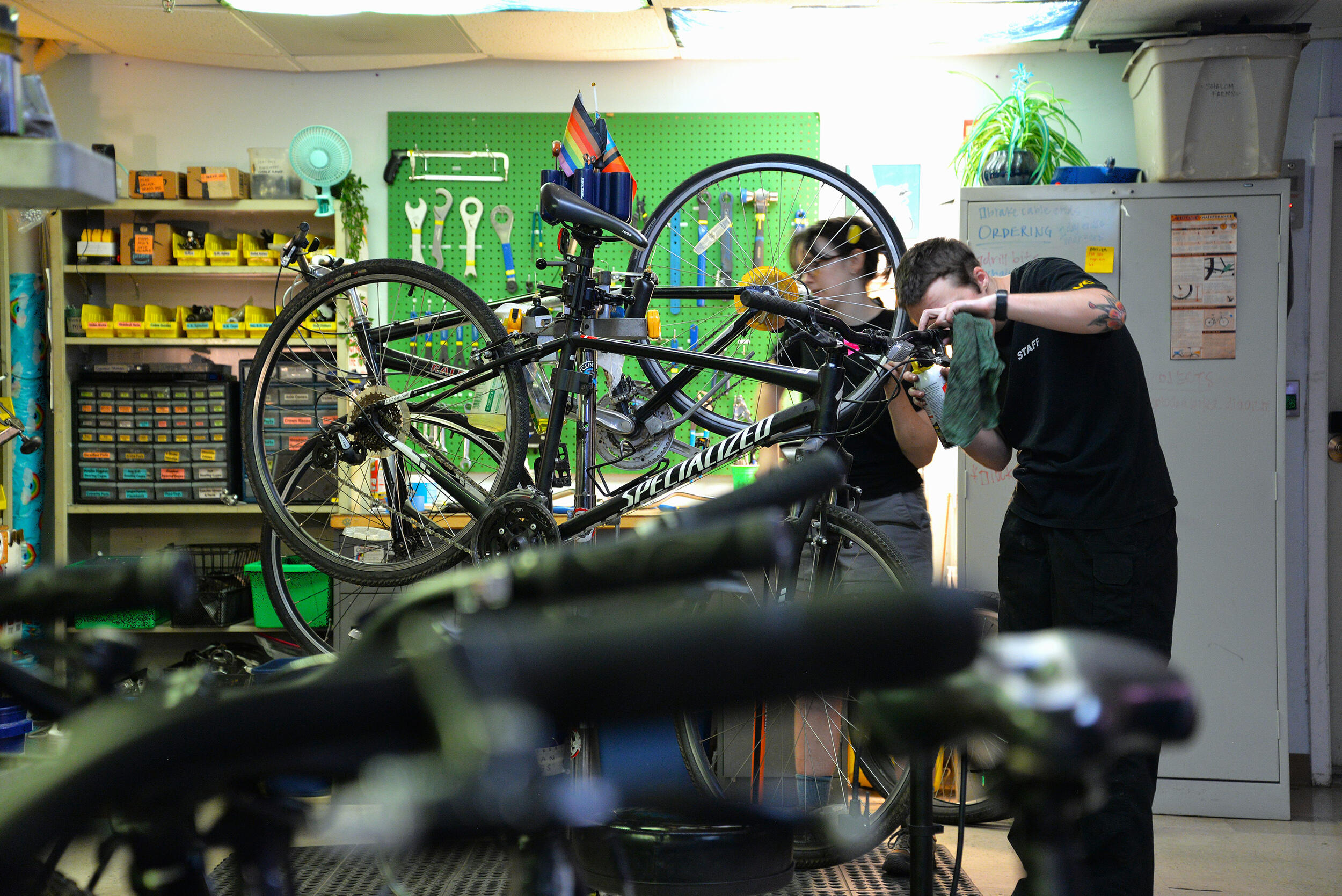 A photo of two people repairing bikes. 