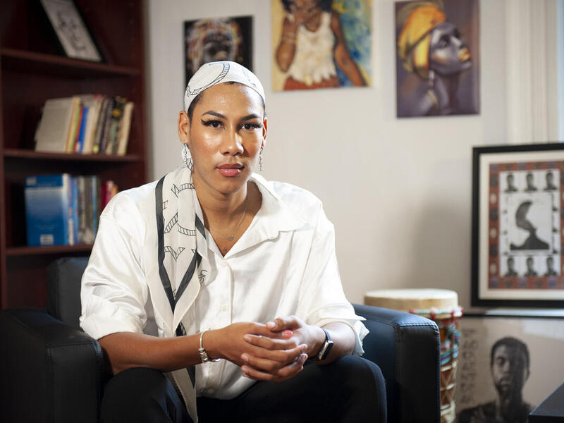 A person wearing a headscarf sitting in a chair. 
