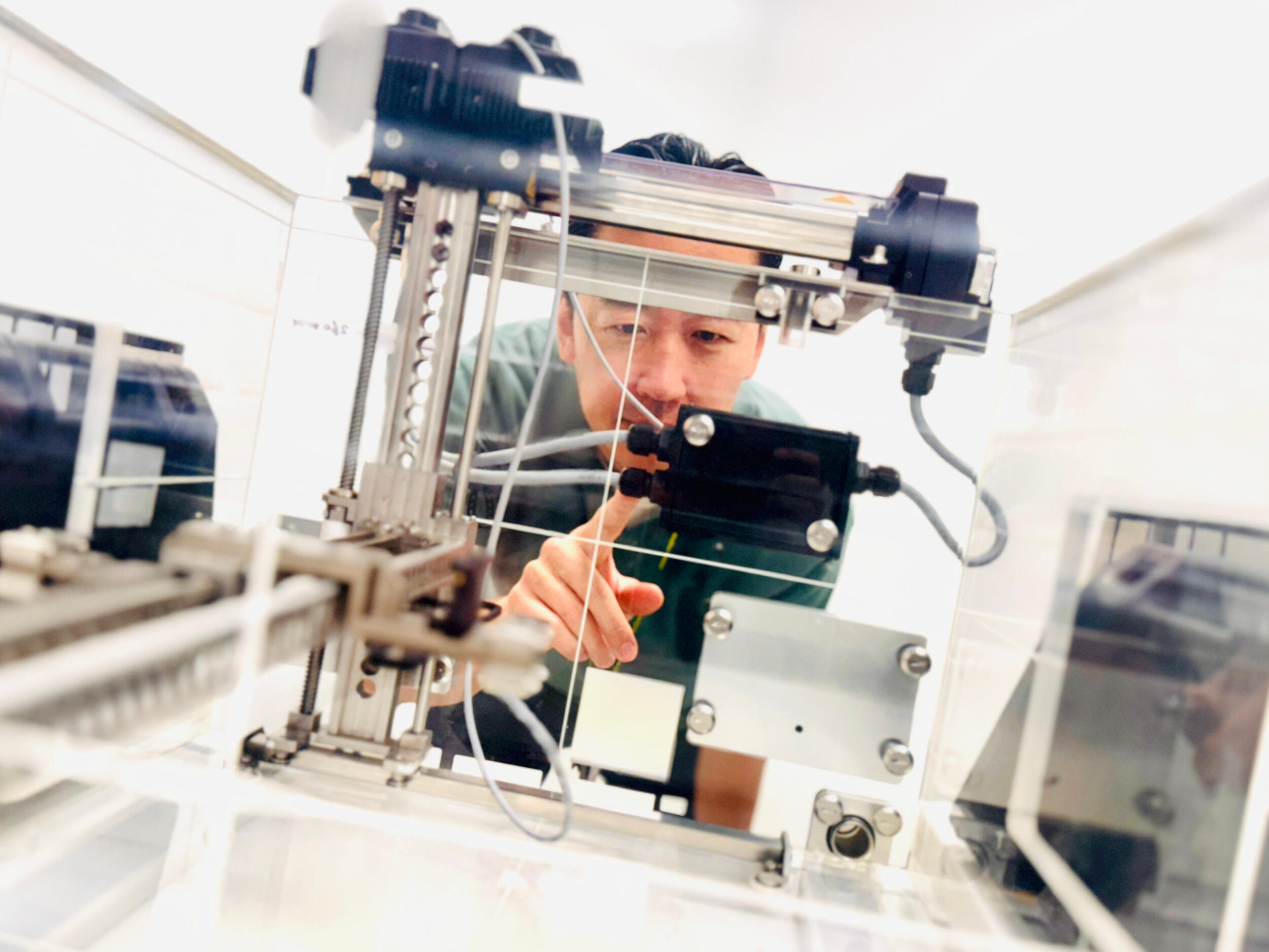 A mean leans and studies a portable water tank device.