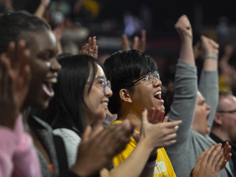 A photo of a row of people clapping and cheering