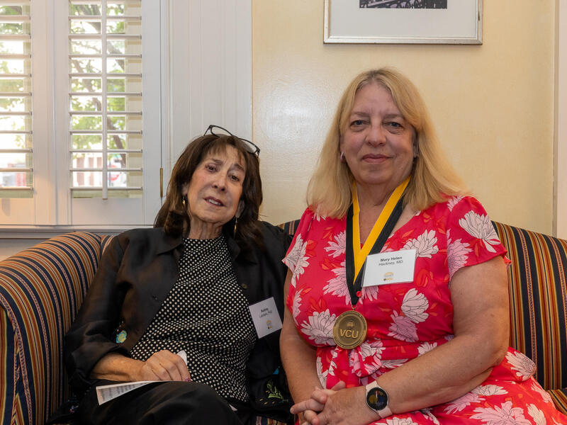 A photo of two women sitting on a couch. 