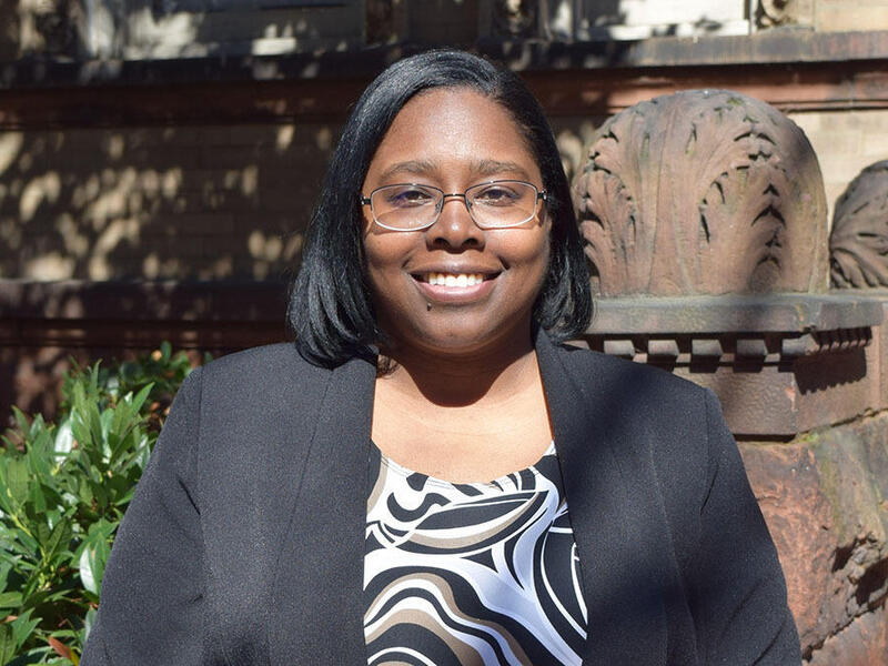A photo of a woman from the chest up standing outside