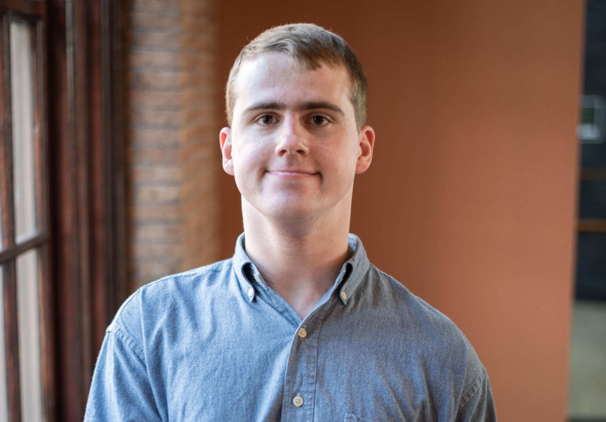 A head and shoulders image of a man in a blue button-down shirt.