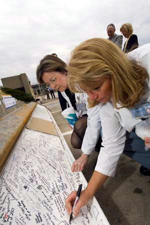 VCU Health System employees inscribe their signatures and messages to the beam before it is lifted to the top of the Critical Care Hospital. Photo by Allen Jones, VCU Creative Services