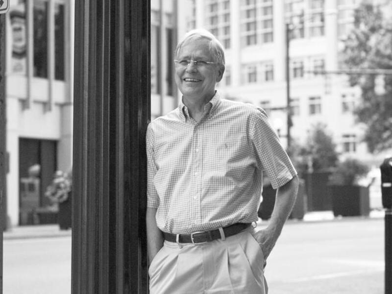 Photo of smiling John Moeser near a lamp post.