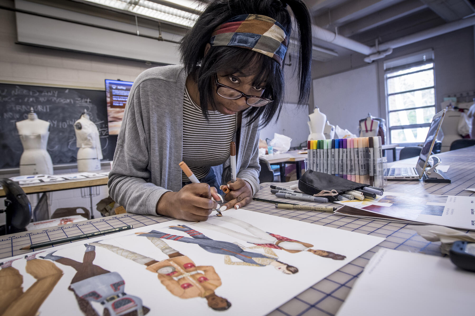 young Black woman working in a fashion design classroom at V C U