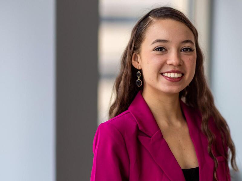 Portrait of woman who is smiling against a white backdrop.