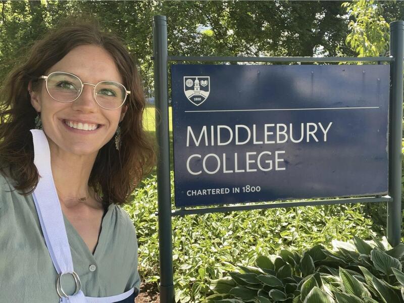 Madeline Doane standing next to a sign that says \"Middlebury College.\"