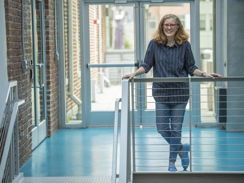 A woman standing in front of railing next to stairs. 