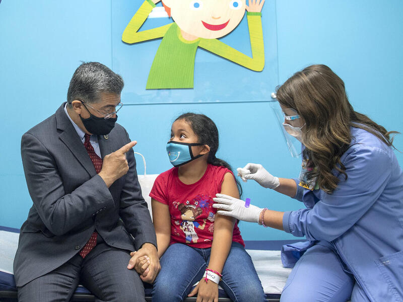 Mary Picado speaks with U.S. Secretary of Health and Human Services Xavier Becerra and Virginia Gov. Ralph Northam. 