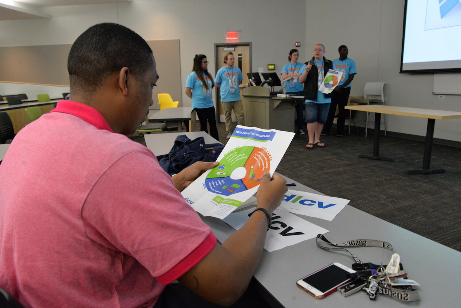 Devin Coleman, communications coordinator for the disAbility Law Center of Virginia, checks out a poster created for his organization by VCU students while Matt Grizzle, a senior creative advertising major in the Robertson School, explains the design. (Photo by Brian McNeill)