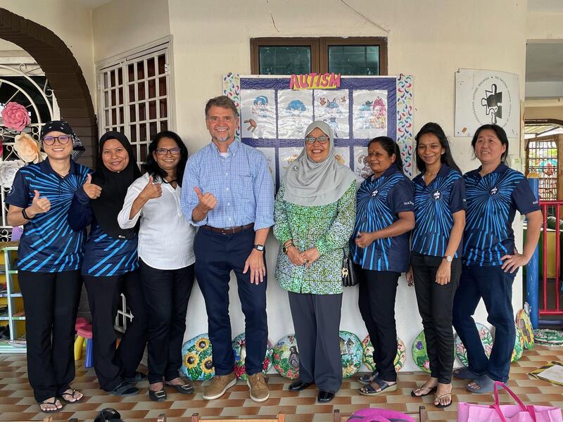 Eight people standing next to eachother in a group photo. 