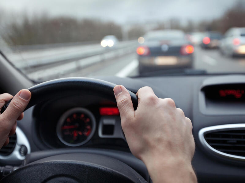 A steering wheel with two hands on it. 