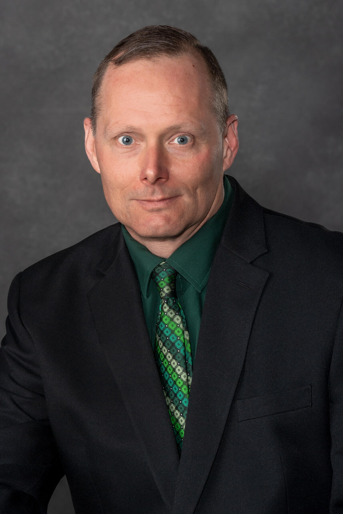 A photo of a man from the chest up. 