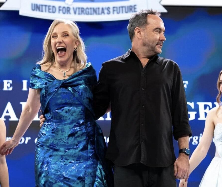 A photo of a woman standing to the left of a man on a stage. 