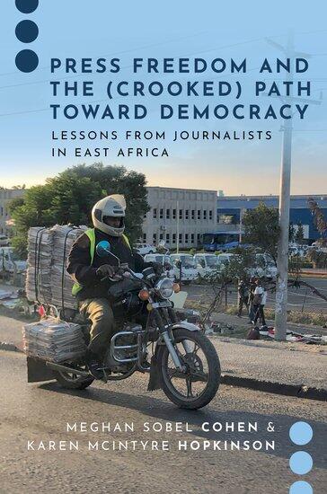 A book cov er that says \"PRESS FREEDOM AND THE (CROOKED) PATH TOWARD DEMOCRACY LEASSONS FROM JOURNALISTS IN EAST AFRICA.\" The book cover has a photo of a man rididng a motor bike with stacks of newspapers on it. 