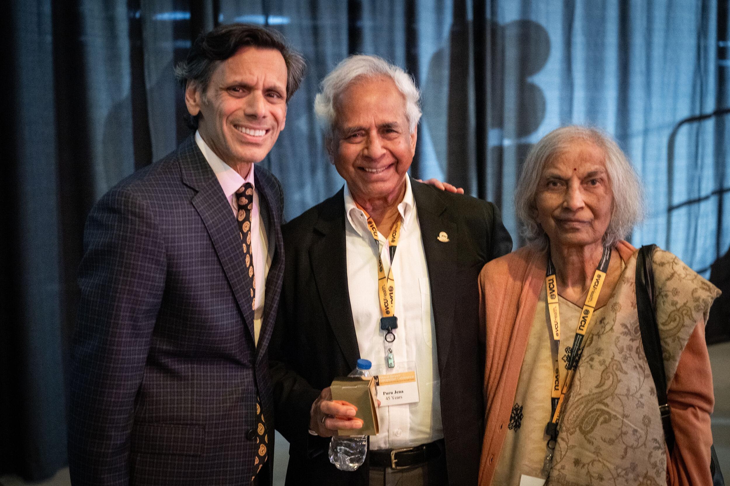 A photo of three people from the waist up. 