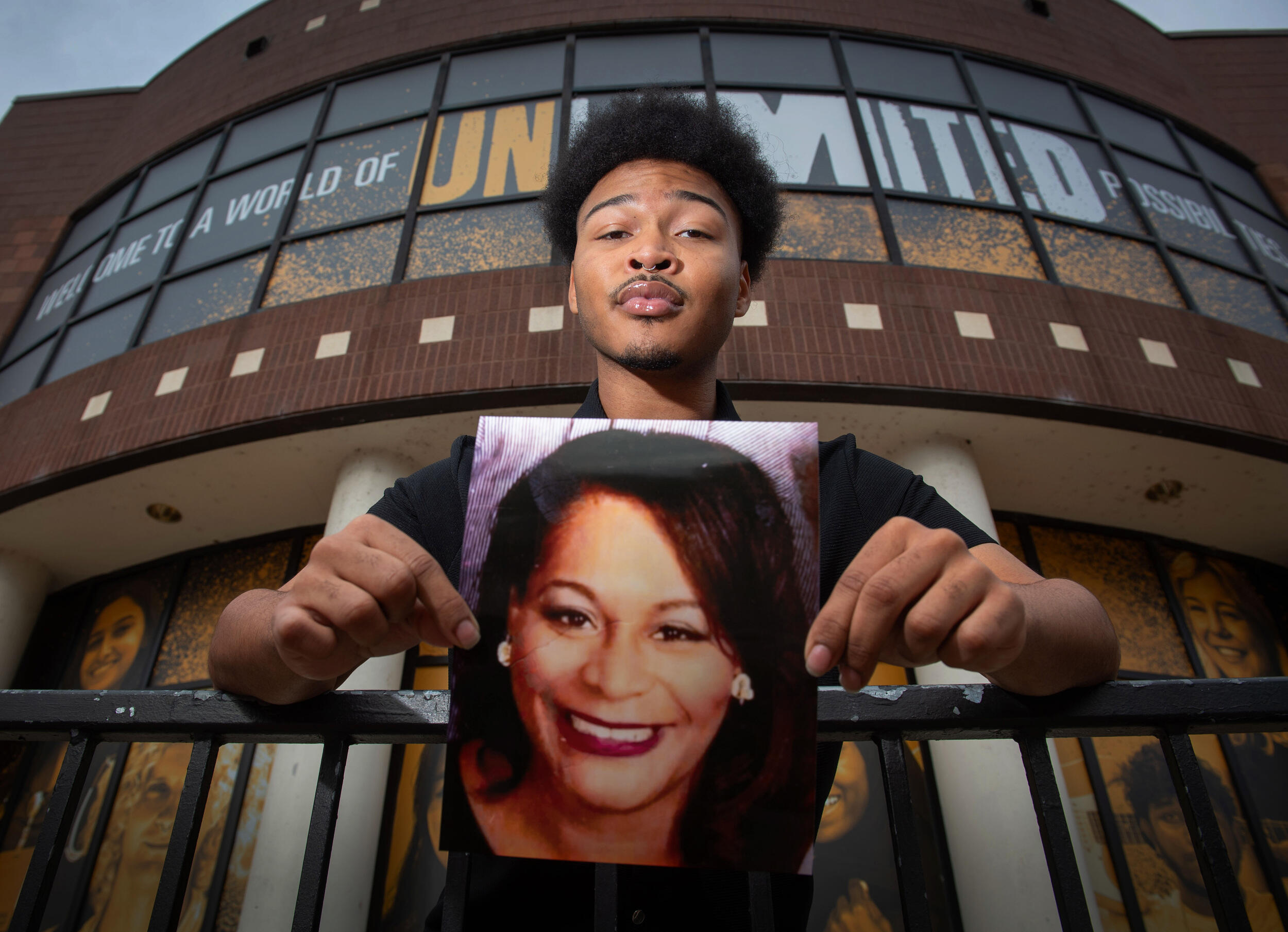 A photo of a man holding a photo of a woman's face. 